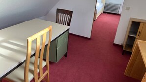 A small, compact room with a dining table and chairs, a green cabinet, and a radiator. - Room in Guest Room - Pension Forelle - Double Room n01 (Forbach)