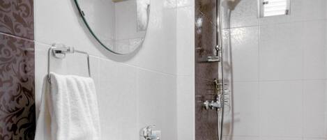 A bathroom with a white sink, wooden cabinet, mirror, and shower.