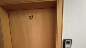 A wooden door with the number 17, a door handle, and a doorbell with the number 122. - Room in Guest Room - Comfortable Single Room With Shared Bathroom and Kitchen (Forbach)