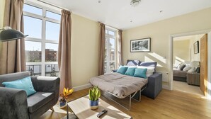 Un dormitorio moderno con cama, mesita de noche y vistas a la ciudad.