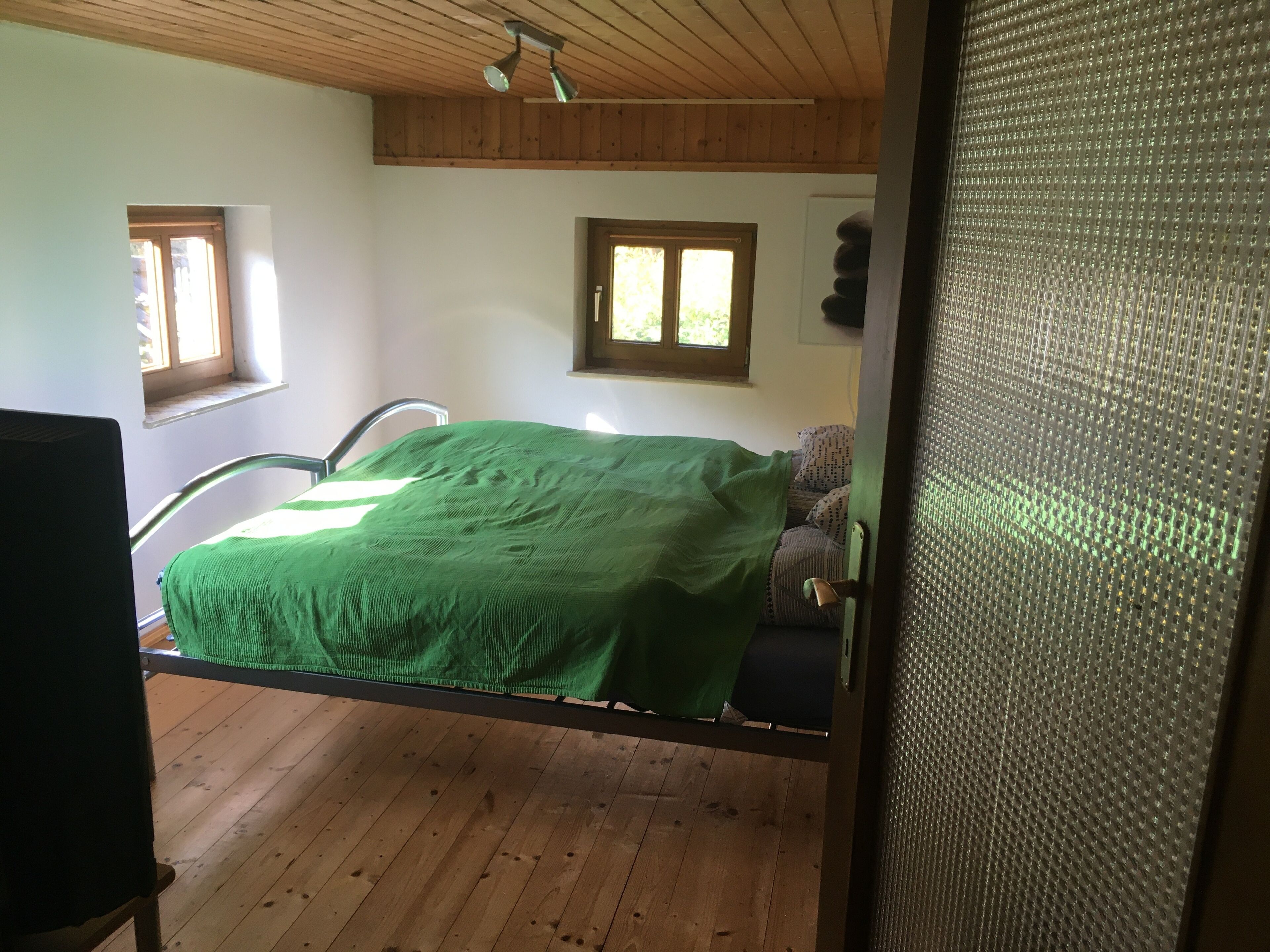 Ein Zimmer mit einem Bett, einem Sessel und einem Fenster.