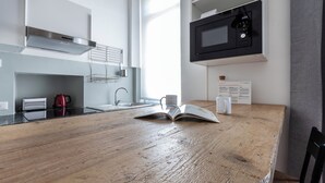 A modern kitchen with a wooden countertop, stainless steel appliances, and a microwave. - Italianway - Umbria 50 B (Milan)