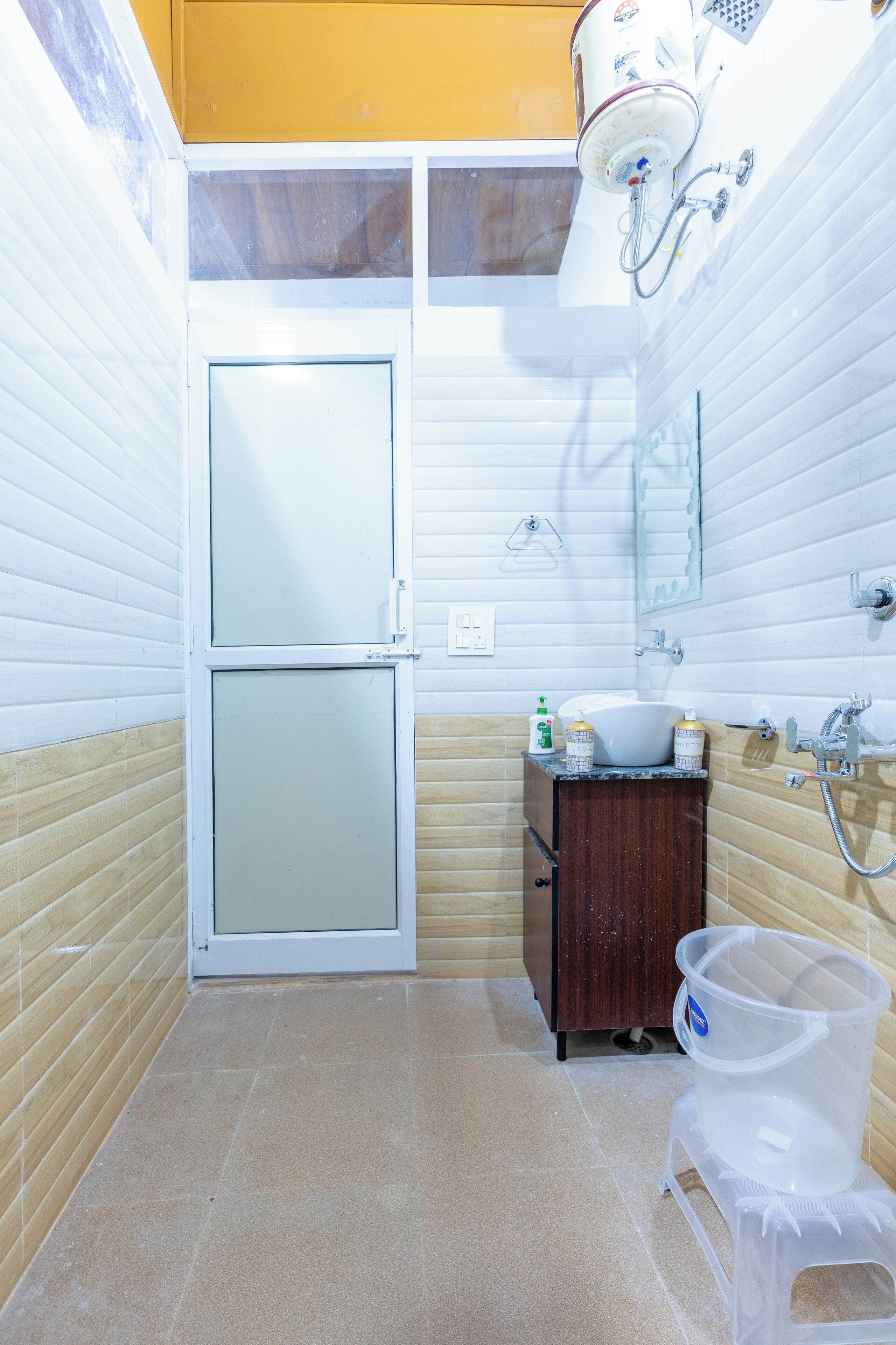 A bathroom with a toilet, sink, mirror, and shower.