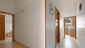 A spacious hallway with a tiled floor, wooden doors, and a view into a kitchen area. - 3797 Casa di Marì by Barbarhouse (Melendugno)