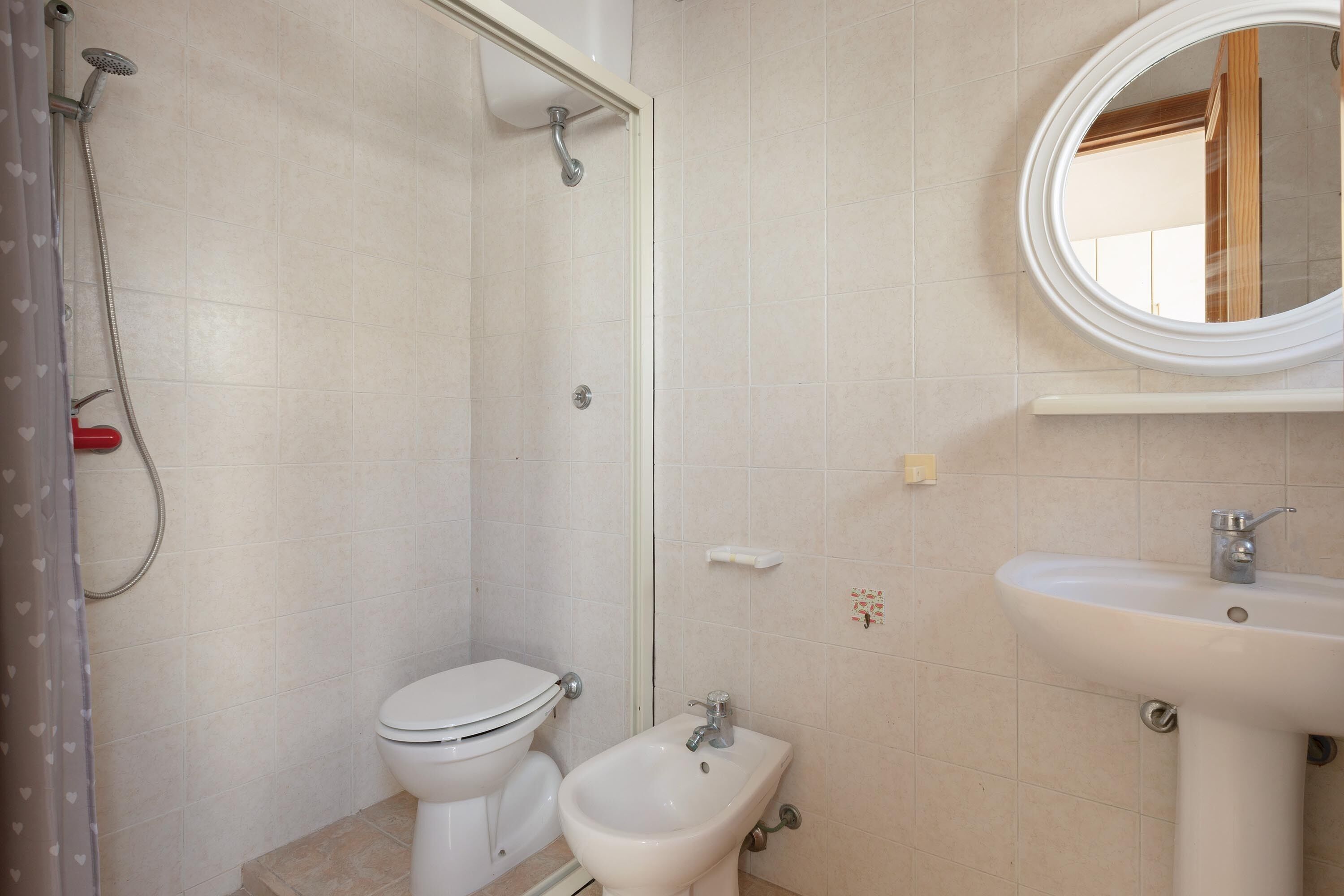 Un baño con inodoro, bidé y lavamanos.