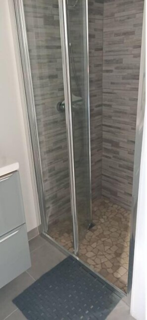 Een douche, een haardroger, handdoeken, toiletpapier