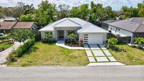 A modern two-story house with a front porch, a driveway, and a well-maintained lawn.