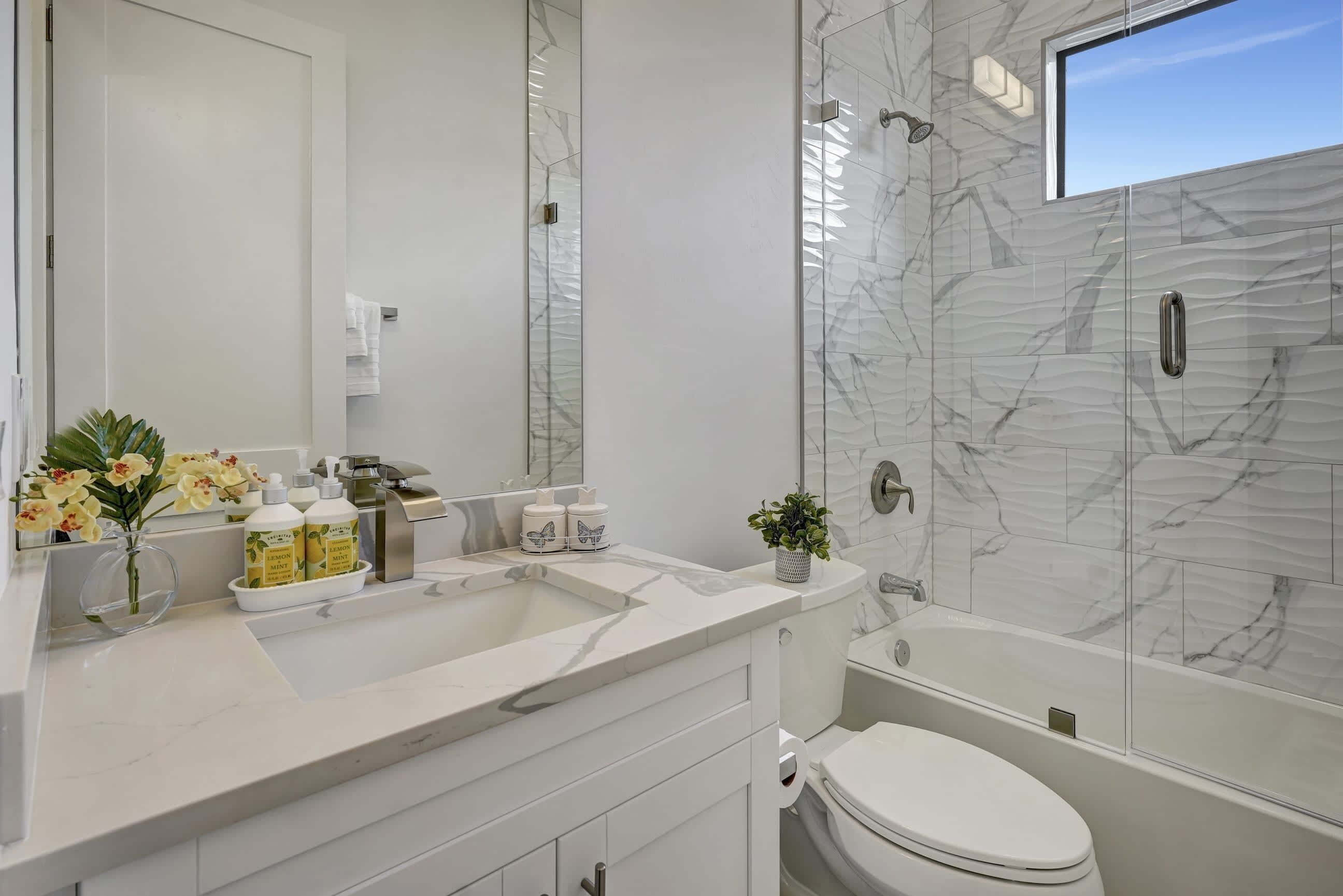 Un baño moderno con tocador doble, inodoro y bañera.