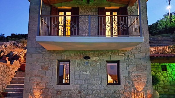Ein Gebäude aus Stein mit einem Balkon, zwei Fenstern und einer Treppe, die zum Eingang führt.