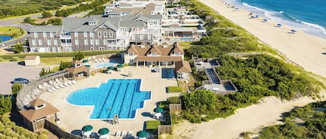 A coastal hotel with a large swimming pool, beach access, and multiple guest rooms.