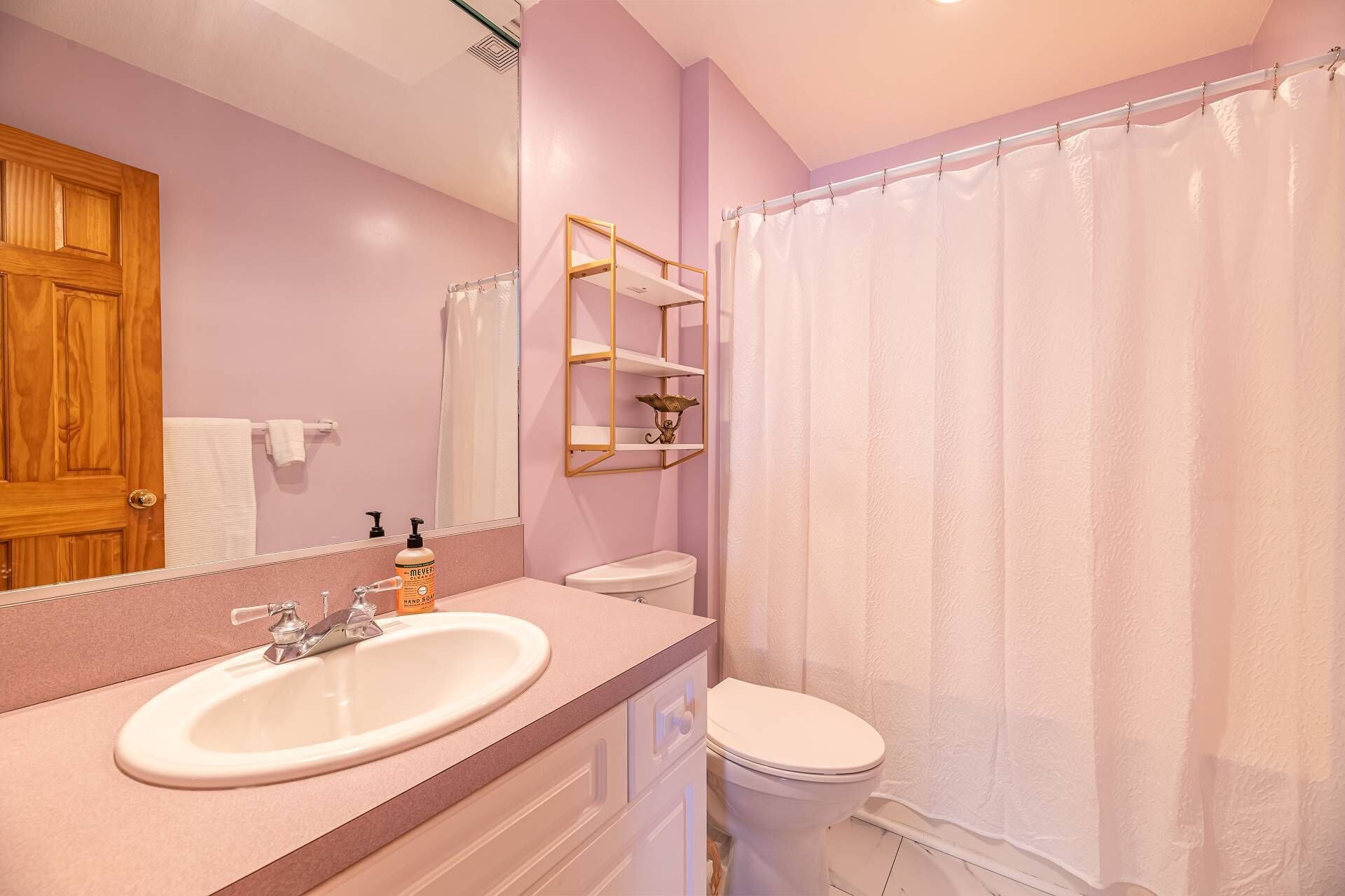 A bathroom with a sink, toilet, and shower curtain.
