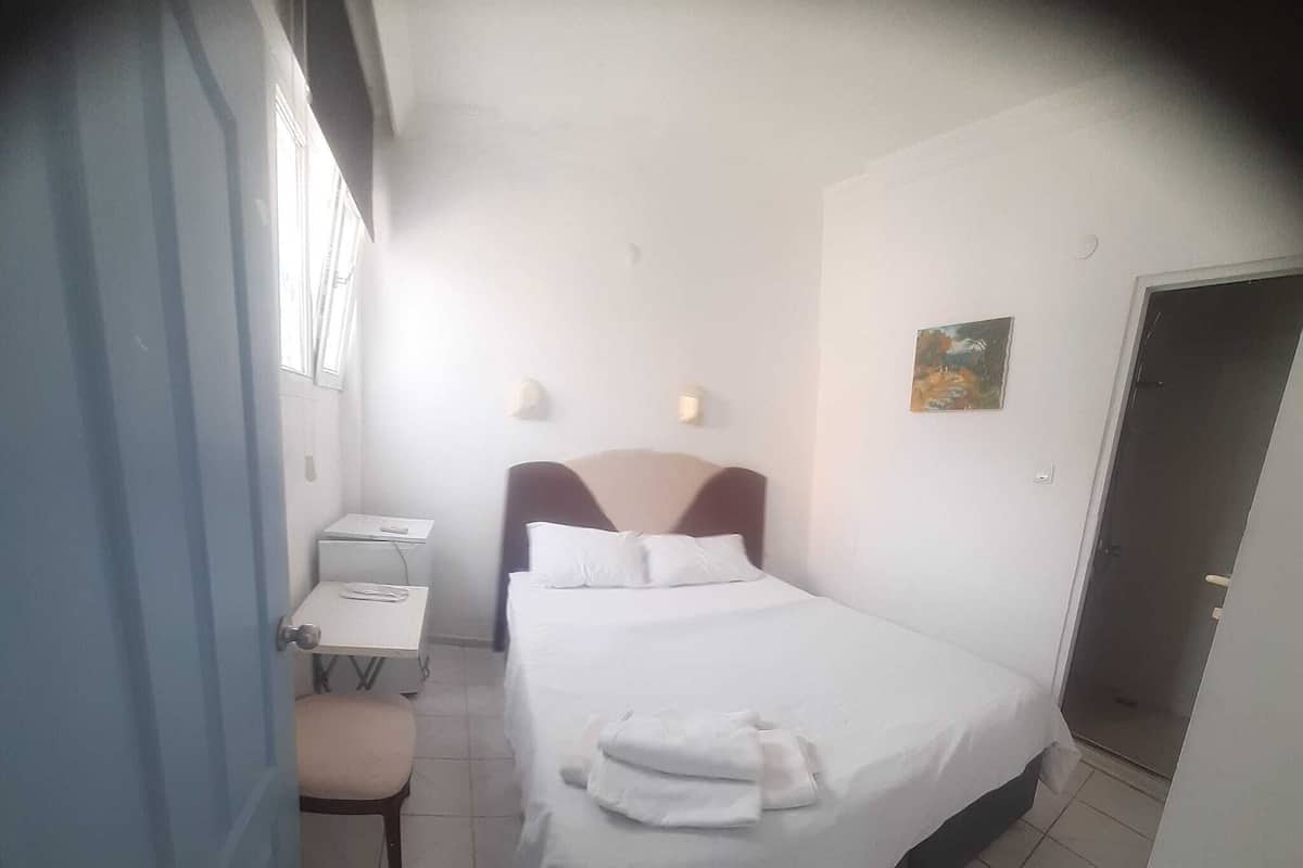 Ein Hotelzimmer mit Bett, Schreibtisch und Stuhl.