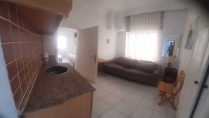 A compact living space with a kitchenette, a sofa, and a dining area. - Kibar Apart Pansiyon (Kusadasi)