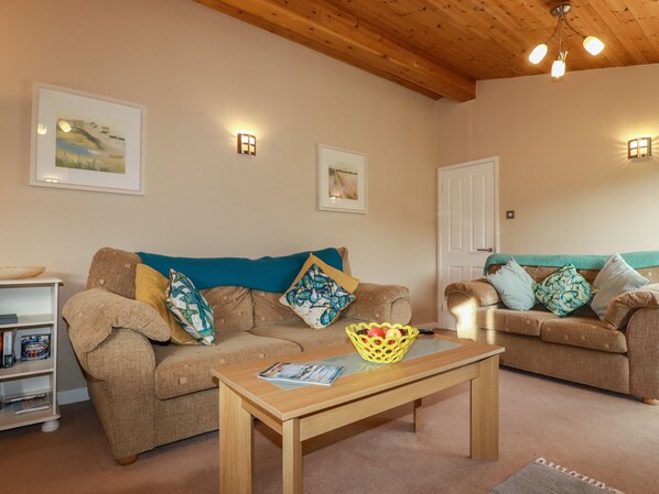 A cozy living room with two sofas, a wooden coffee table, and a small side table.