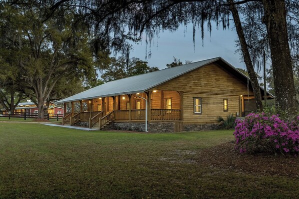 A wooden cabin with a porch, surrounded by trees and a grassy area. - Tranquil Suite w/ Porch < 2 Mi to Cedar Lakes! (Williston)