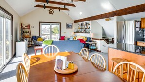 A spacious kitchen with a dining area, wooden beams, and a view to the outside. - Eastham Beach House w/ Bay Views & Beach Access! (Eastham)
