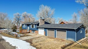 A residential house with a garage, a deck, and a clear blue sky. - Charming Elk Mountain Home: Hunt, Hike & Fish! (Elk Mountain)