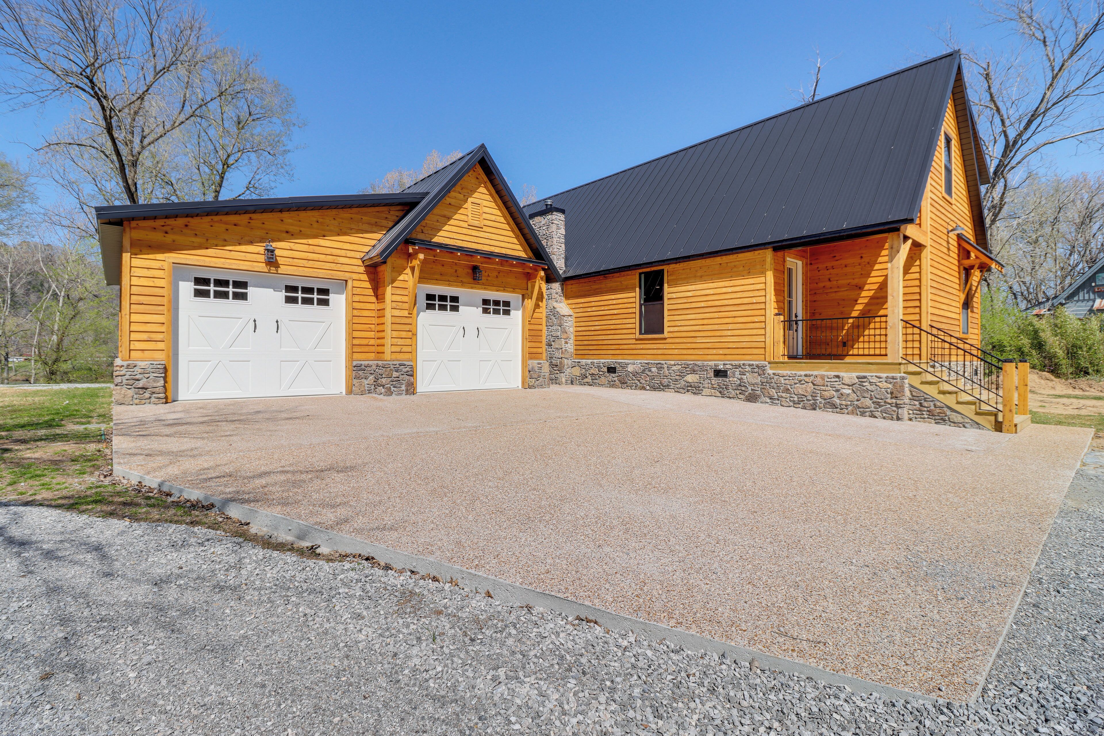 A two-story log cabin with a garage and a covered porch.