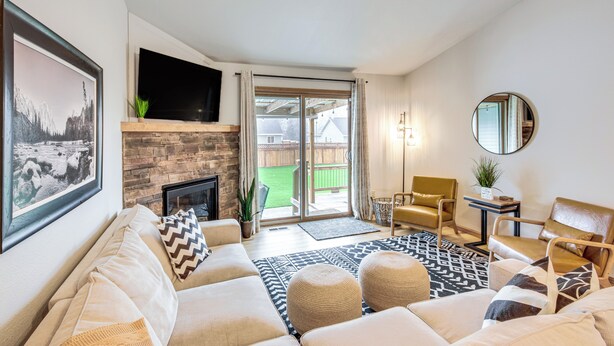 A living room with a fireplace, a sofa, a coffee table, and a TV mounted on the wall.