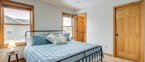 Un dormitorio con cama, ventilador de techo y puertas de madera.