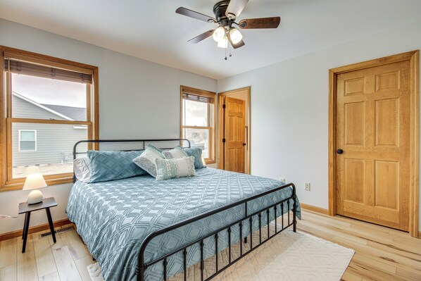 A bedroom with a bed, a ceiling fan, and wooden doors. - Beautiful Family Home: 10 Mi to Red Lodge Mountain (Red Lodge)