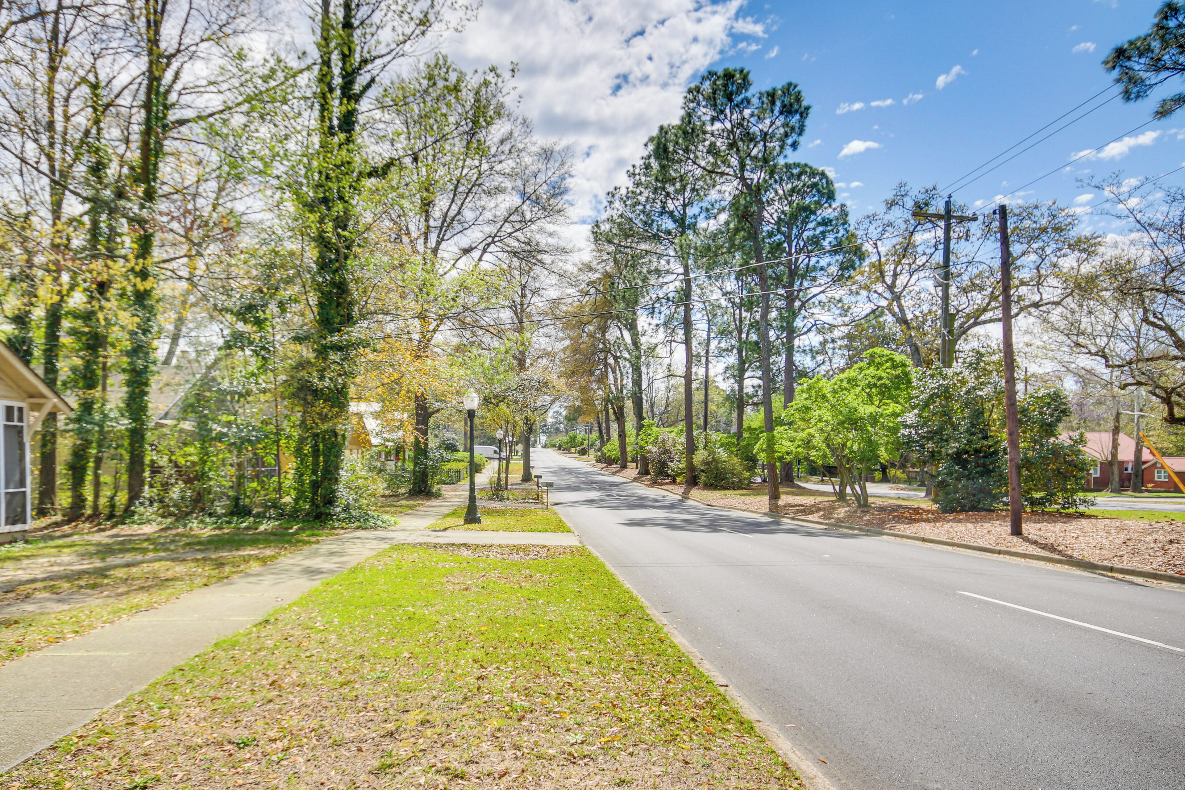 A residential street lined with trees and houses.