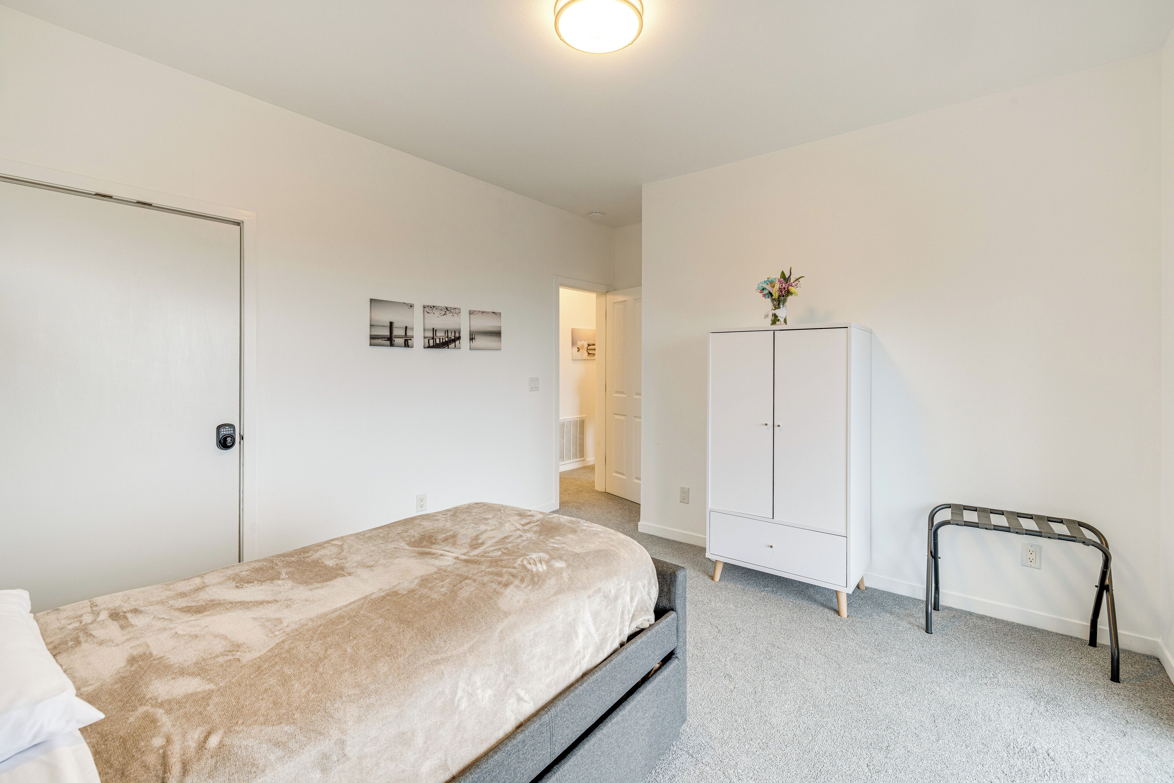 Ein Schlafzimmer mit einem Bett, einem Kleiderschrank, einer Bank und einer Tür.