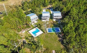 An aerial view of a property with multiple buildings, a swimming pool, and solar panels. - The Clermont at Clermont Bay (Hancock County)