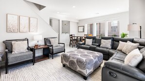 A modern living room with a sectional sofa, a chaise lounge, a coffee table, and a dining area with a table and chairs. - Haven in the Sand: 4 beds 3.5 baths, sleeps 10.  Community Pool. (Washington)