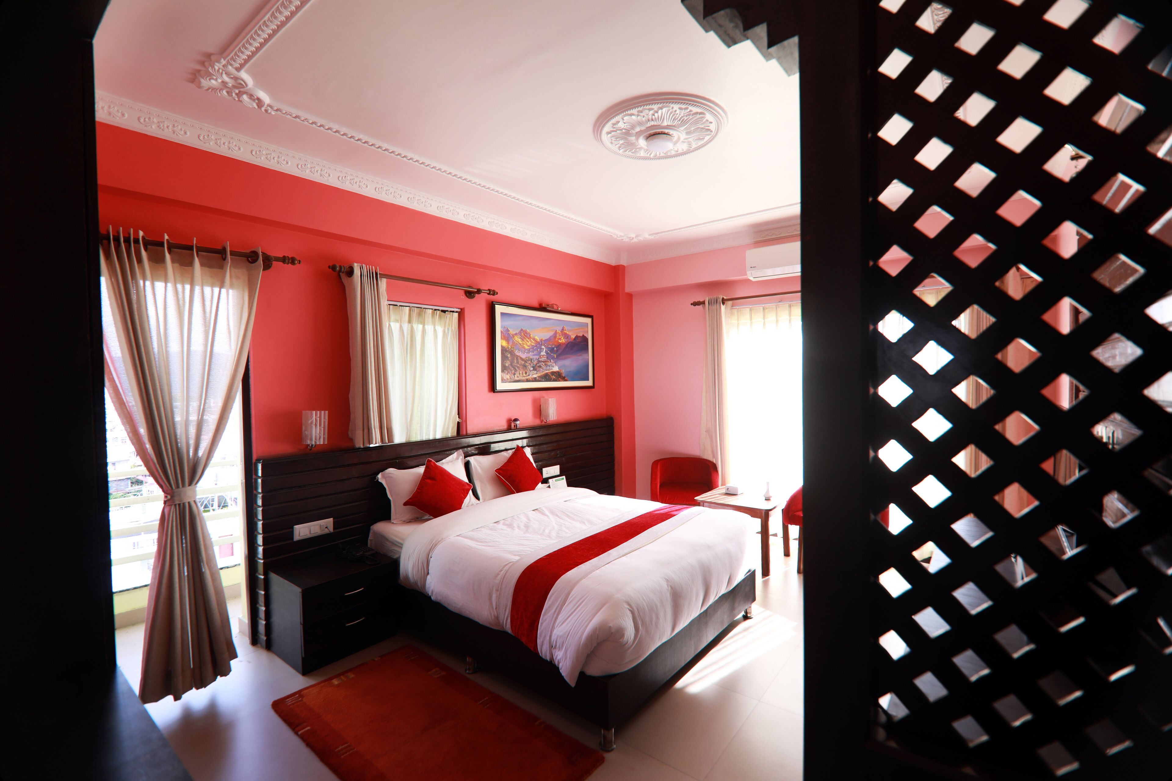 A bedroom with a large bed, a nightstand, a desk, and a chair.