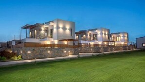 A modern two-story house with a stone facade, a flat roof, and a well-maintained lawn. - Stefi Deluxe Villas - Avgi Private Pool Retreat (Anopoli)