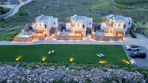 Un edificio residenziale moderno, a più piani, con un prato curato e un’area salotto all’aperto.