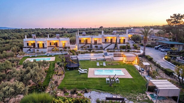 Eine moderne Villa mit mehreren Schlafzimmern, einem Swimmingpool und einem gepflegten Garten.