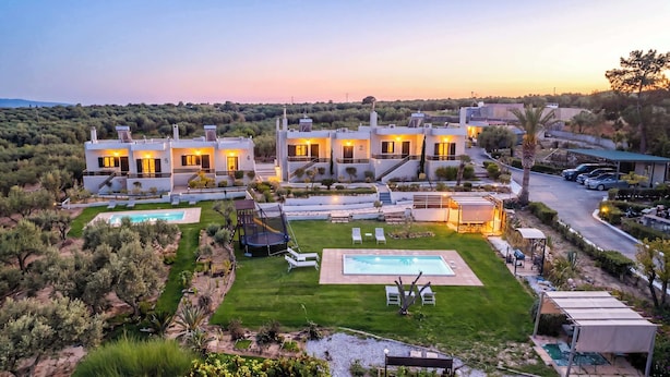 Uma villa moderna com vários quartos, piscina e um jardim bem cuidado.