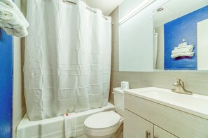 Een badkamer met een bad, toilet en wastafel.