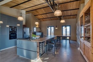 A modern kitchen with a central island, stainless steel appliances, and pendant lighting.