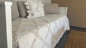 A beige sofa with a textured throw blanket and decorative pillows. - Villa 60m² with garden, air conditioning and parking - up to 6 people (La Roquette-sur-Siagne)