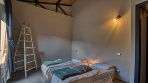 Ein Schlafzimmer mit zwei Betten, einer Leiter und einer Wandleuchte.