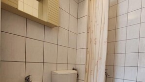 A bathroom with a toilet, sink, and shower.