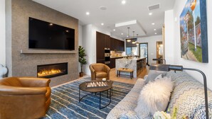 Luxe resortwoning | Woonruimte | Een 50-inch smart-tv met kabelzenders en een open haard