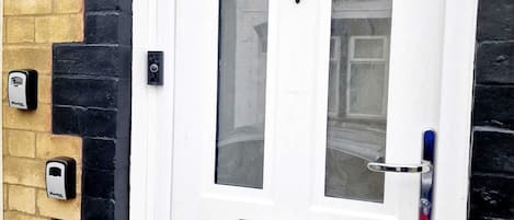 A white door with the number 6, a mail slot, and a doorbell.