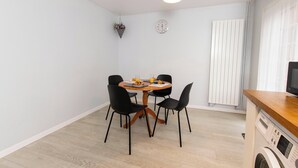 A compact kitchen with a dining area, a washing machine, and a radiator. - 5 Guests - 2-bed House - Bbq - Free Parking (Norwich)