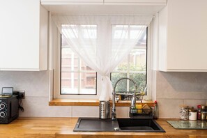 A kitchen with a window, a sink, a coffee machine, and a window seat. - 5 Guests - 2-bed House - Bbq - Free Parking (Norwich)
