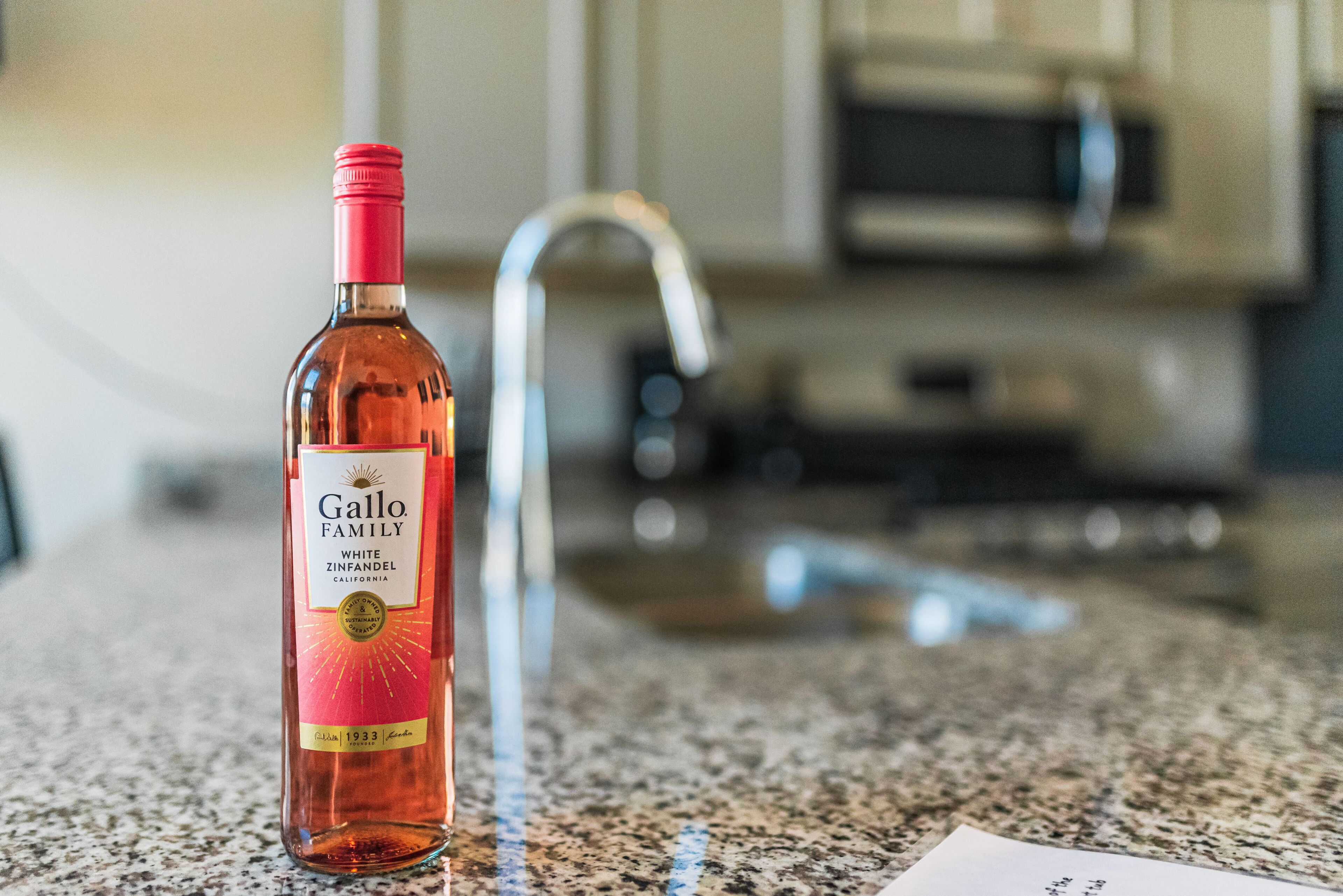 Pullollinen Gallo Family White Zinfandel -viiniä keittiön työtasolla.
