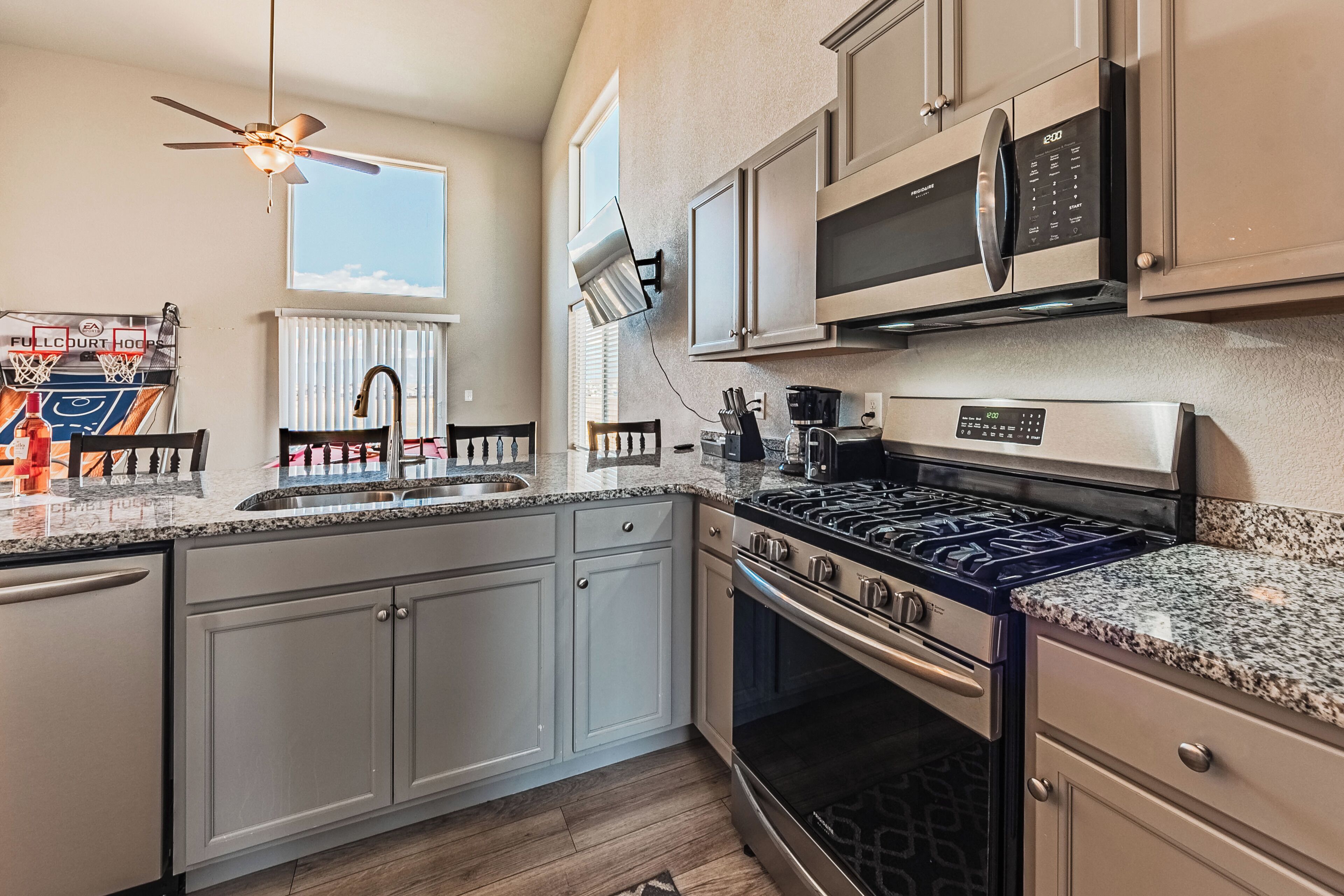 A kitchen with a stove, oven, microwave, and a ceiling fan.