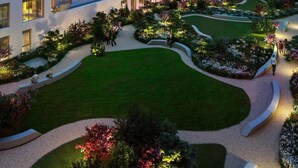 A multi-story hotel with balconies, a landscaped garden, and a city skyline view. - Designer Penthouse Panoramic Views London 2 Beds (London)