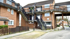 Un immeuble résidentiel à plusieurs étages, doté d’escaliers et de balcons extérieurs.