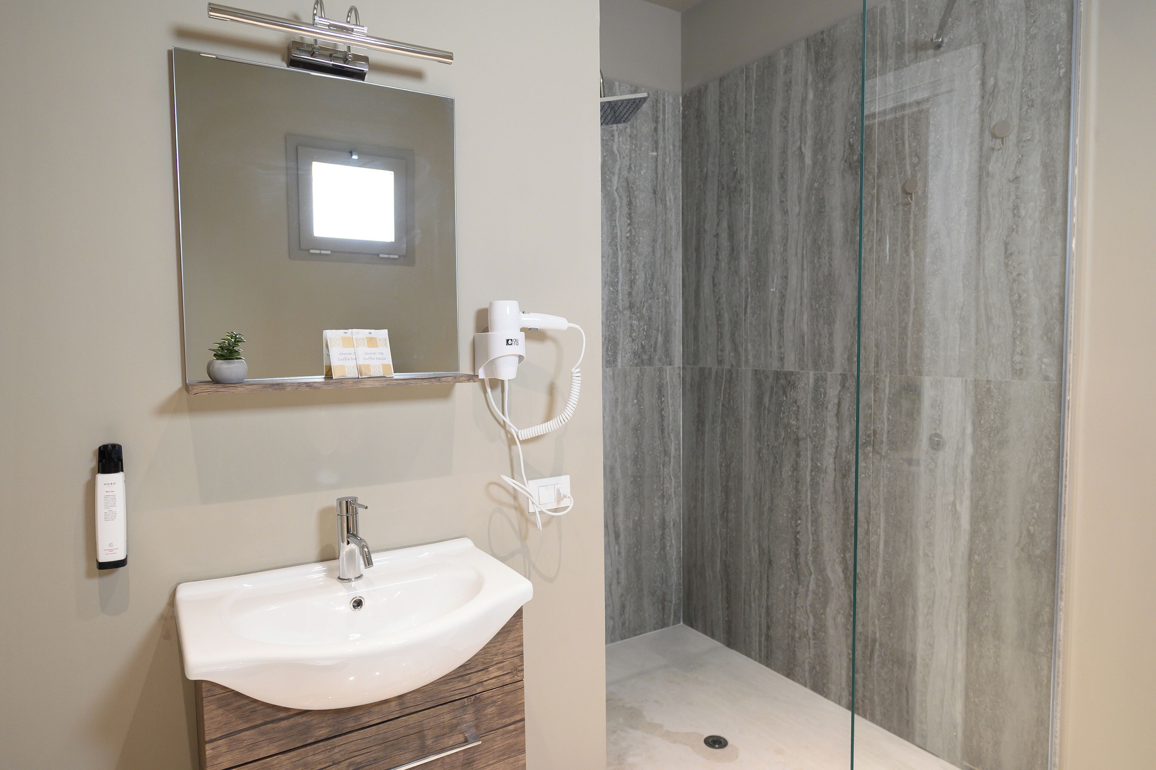 A modern bathroom with a white sink, mirror, and handheld showerhead.