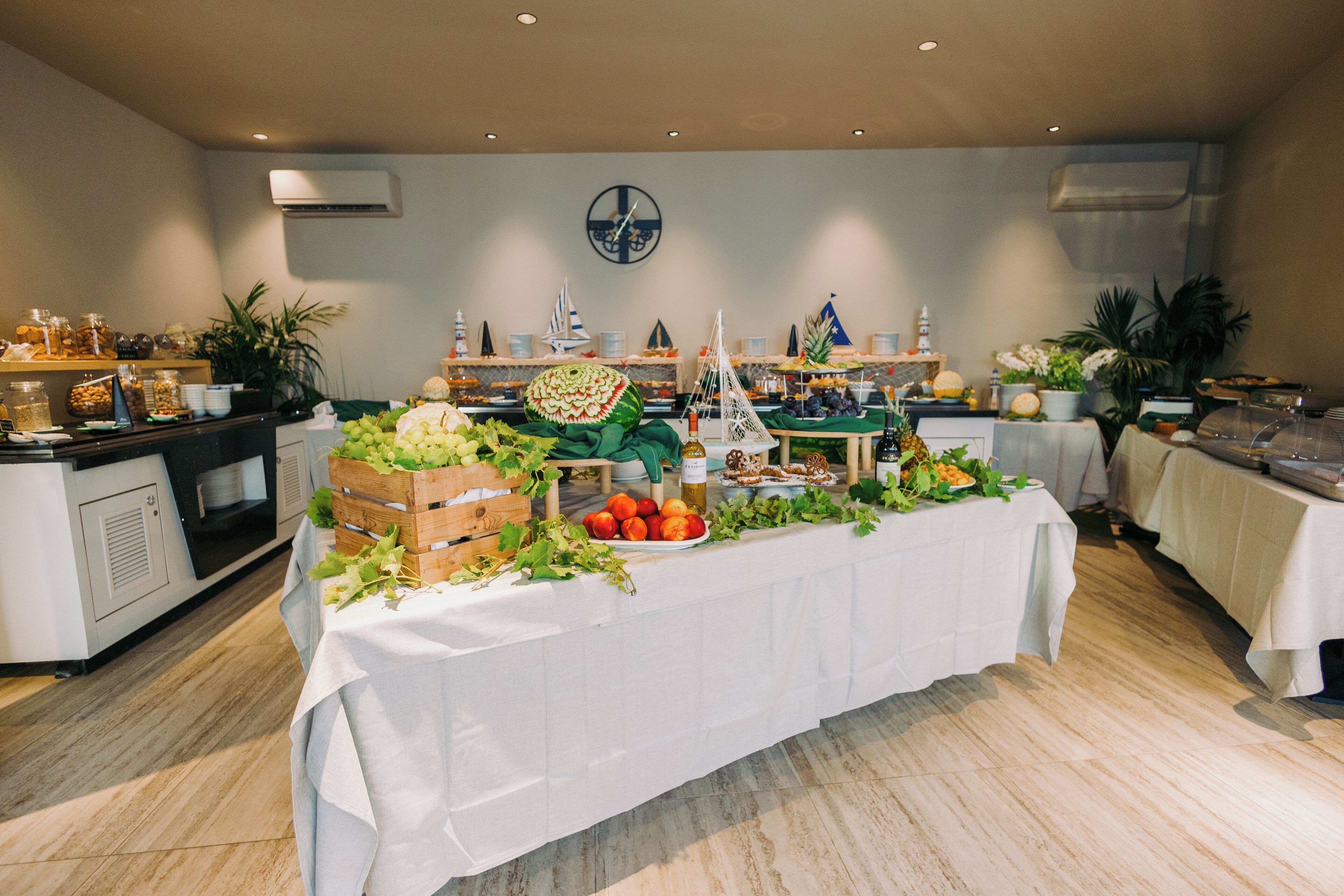 A buffet setup with a variety of food items and decorations, including fruits, vegetables, and themed centerpieces.