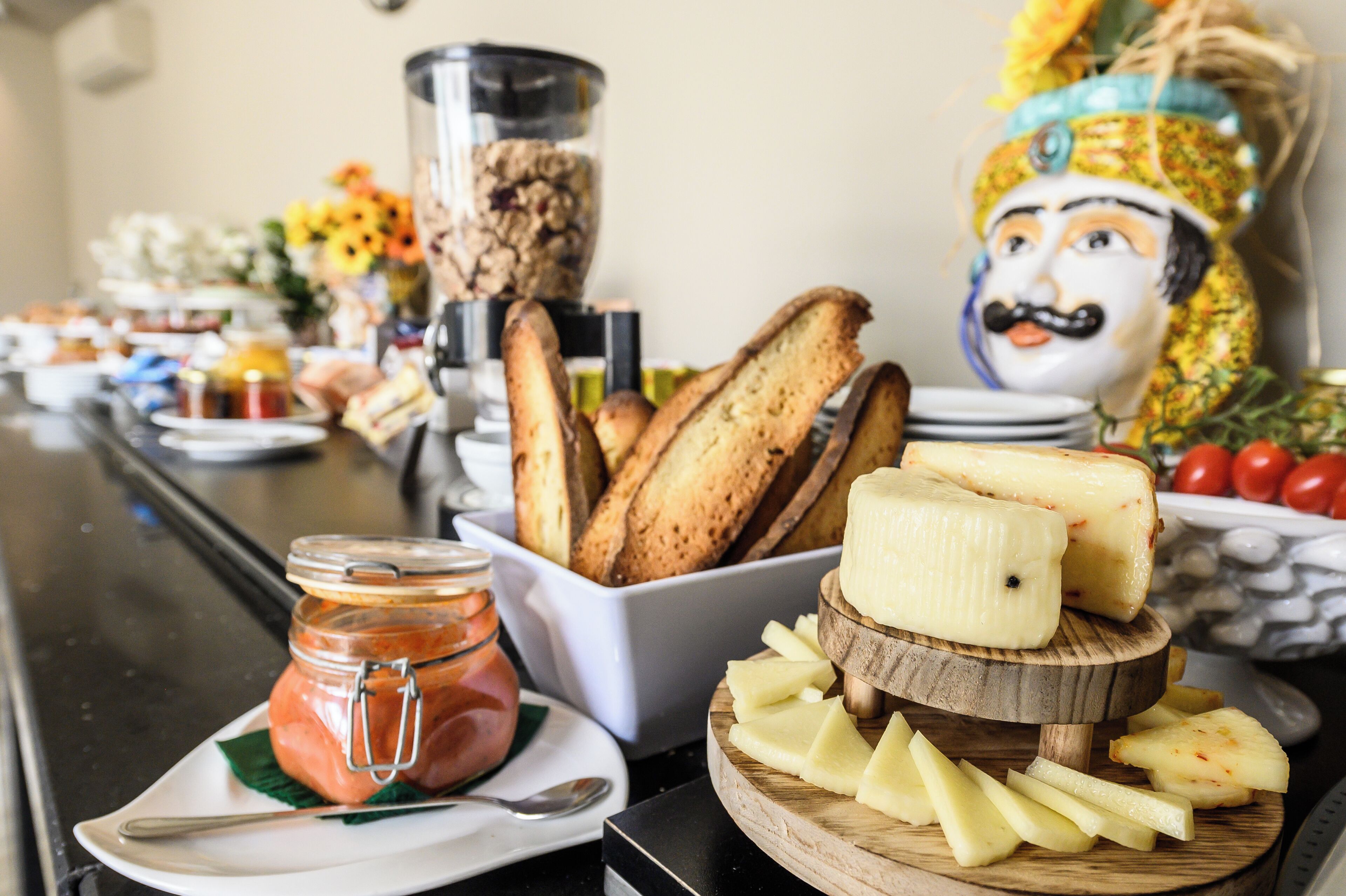 A buffet with various food items including bread, cheese, and a jar of jam.